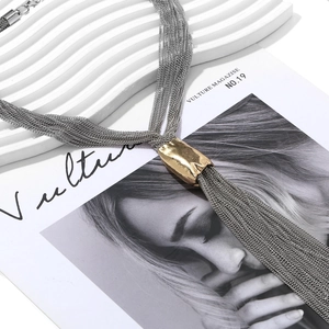 Detail of multi-layer metal fringe necklace with silver chains and golden tube accents