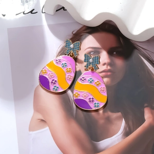 Detail of Easter egg earrings with blue bow and colorful oil-dripped floral pattern