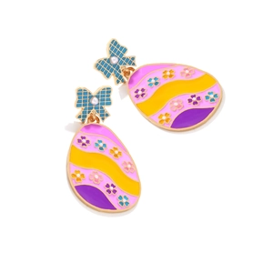 Macro detail of Easter egg earrings with colorful enamel patterns and bow accents