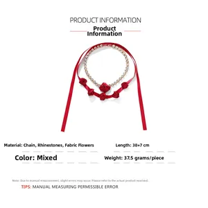 Gros plan du ras-du-cou rose en tissu rouge et collier de strass sur fond blanc