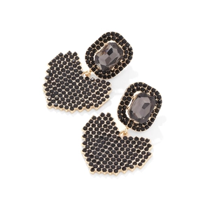 Vue détaillée de grandes boucles d'oreilles cœur dorées avec strass noirs et cristaux gris