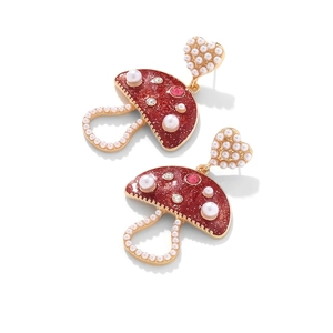 Detail of mushroom earrings with red glitter enamel, white pearls and gold accents
