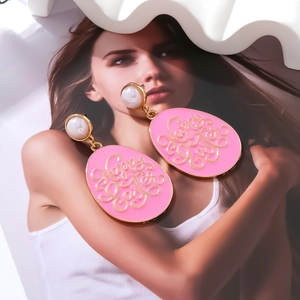 Detail view of pink enamel Easter egg earrings with gold Happy Easter lettering