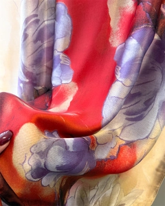 Close-up of red and purple floral silk scarf showing smooth satin texture and drape