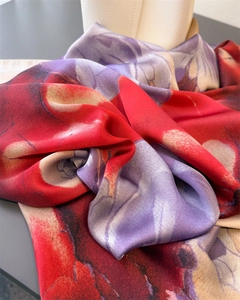 Detail of silk-like floral scarf with vibrant red and purple patterns and smooth texture