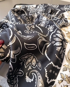 Detail of vintage paisley print silk scarf showing smooth texture and glossy fabric finish