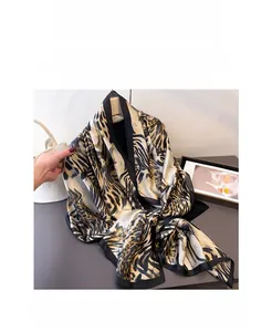 Detailed view of leopard print silk scarf with fine black hemmed edges and animal pattern