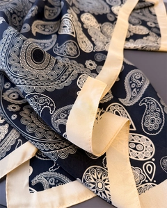 Close-up of black and white paisley silk scarf showing fine stitching and soft fabric texture