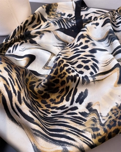 Detailed macro view of leopard print faux silk scarf with elegant golden and black patterns