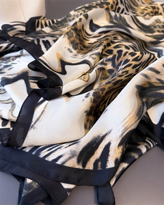 Macro view of silky leopard print scarf with elegant black borders and satin texture