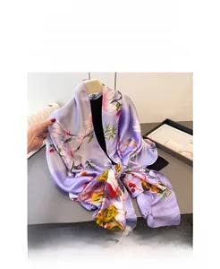 Detail shot of purple floral faux silk scarf with elegant magnolia prints and texture