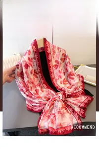 Detailansicht des roten Satin-Schals mit Seidentextur und eleganten Blumen-Drucken