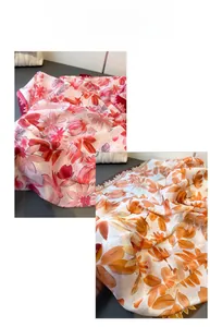 Detail eines Seidenschals mit Blumenmuster in Rosa- und Orangetönen und Muster