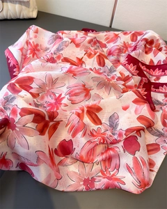 Detailansicht eines Seidenschals mit Blumenmuster in Rosa und Rot-Tönen