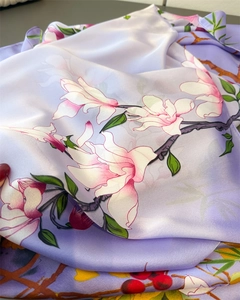 Detailed macro shot showing smooth texture and floral print on lavender silk scarf