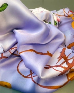 Close-up of lilac floral silk scarf with glossy texture and intricate leaf patterns