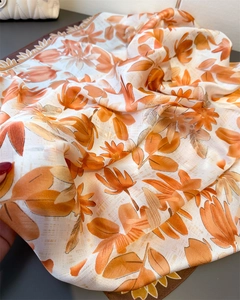 Detail eines Seidenschals mit Blumendruck, glatter Satinstruktur und eleganten Rollkanten