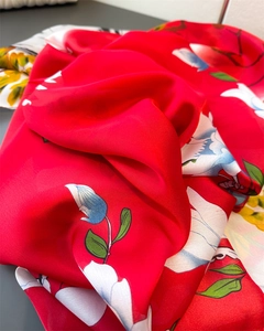 Macro shot of red faux silk scarf with elegant floral prints and glossy satin finish