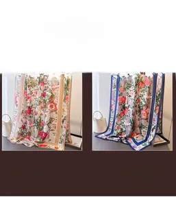 Detail of floral silk scarves with beige and navy borders on a display stand