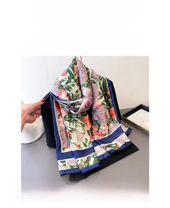Detailed view of floral silk scarf with vibrant purple flowers and blue hem borders