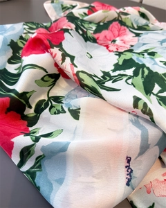 Detailed close-up of vibrant floral hibiscus print on silky satin fabric shawl texture