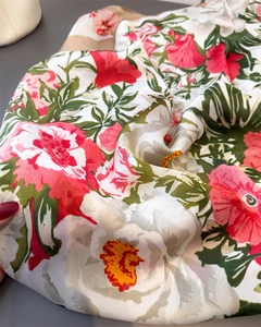 Detailed view of large red and pink floral prints on smooth satin silk scarf fabric