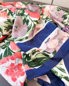 Detailed close-up of floral print silk scarf featuring vivid blooms and navy blue borders