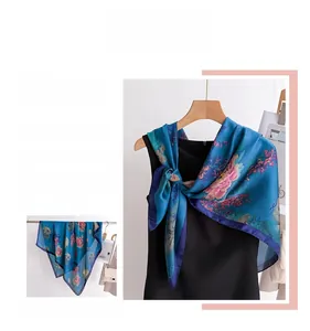 Detail of vintage floral silk scarf with elegant pink and orange blossoms on blue fabric