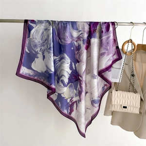 Detail of silk-like scarf with abstract purple floral print hanging on a metal rod