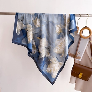 Détail d'un foulard en soie bleue à motif floral suspendu avec des accessoires lifestyle