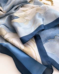 Détail d'un foulard en satin soyeux avec imprimés floraux bleus et coutures fines