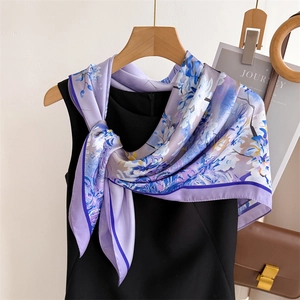 Carré en satin de soie élégant à motif floral lavande et bleu sur une robe noire