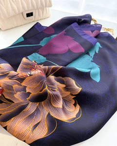 Close-up of luxury floral silk scarf showing vibrant purple and teal patterns