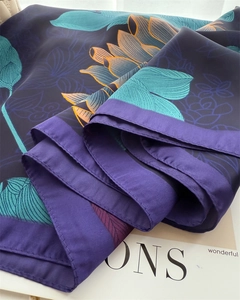 Macro view of floral silk scarf featuring elegant purple lotus prints and satin texture