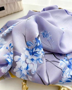 Gros plan détaillé du foulard en soie lavande montrant les fleurs et l'ourlet roulé