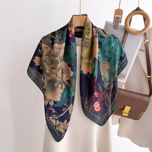 Deep blue floral silk scarf displayed on a hanger with a white sleeveless dress