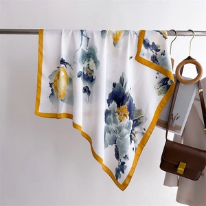 Detail of floral silk scarf showing elegant drape and vibrant patterns on a metal rod