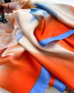 Close-up of premium floral silk scarf showing soft texture and detailed hem stitching