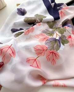 Detailed close-up of glossy leaf print silk scarf showcasing smooth satin fabric texture