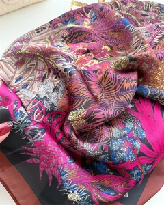 Macro detail of floral silk scarf featuring tropical leaves and satin texture