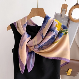 Abstract floral silk scarf with purple and blue print hung on a wooden hanger