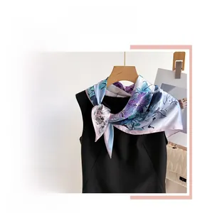 Detailed close-up of a 70cm silk-like square scarf with elegant floral prints on black top