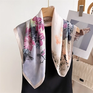 Detailed view of square silk scarf with purple lily print and soft pink edges
