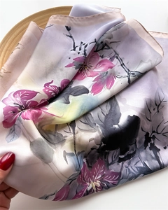 Detail of elegant silk-like square scarf with floral ink print and smooth satin texture