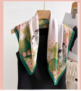 Detail of silk-like scarf featuring lotus and koi fish prints on a cream background