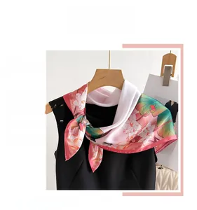 Detail of silk-like scarf featuring pink lotus prints tied elegantly on a mannequin
