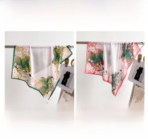 Detail of silk-like square scarf featuring lotus and goldfish print in green and pink