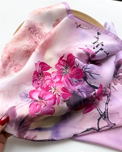 Close-up of silk scarf showing soft floral prints and smooth satin fabric texture