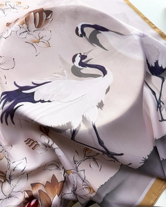 Dettaglio del foulard in seta con stampe di gru e fiori e raffinati bordi arrotolati