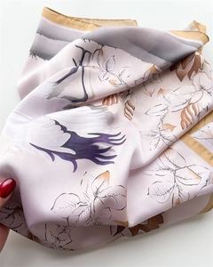 Dettaglio di un foulard in raso di seta con elegante stampa di gru e trama liscia